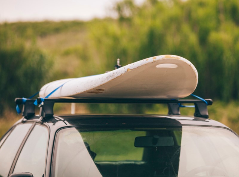 Universeller Dachgepäckträger für Autos transportiert Surfbrett
